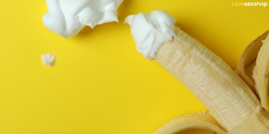 Обелена бананa с бита сметана върху върха - провокативна еротична метафора на жълт фон.